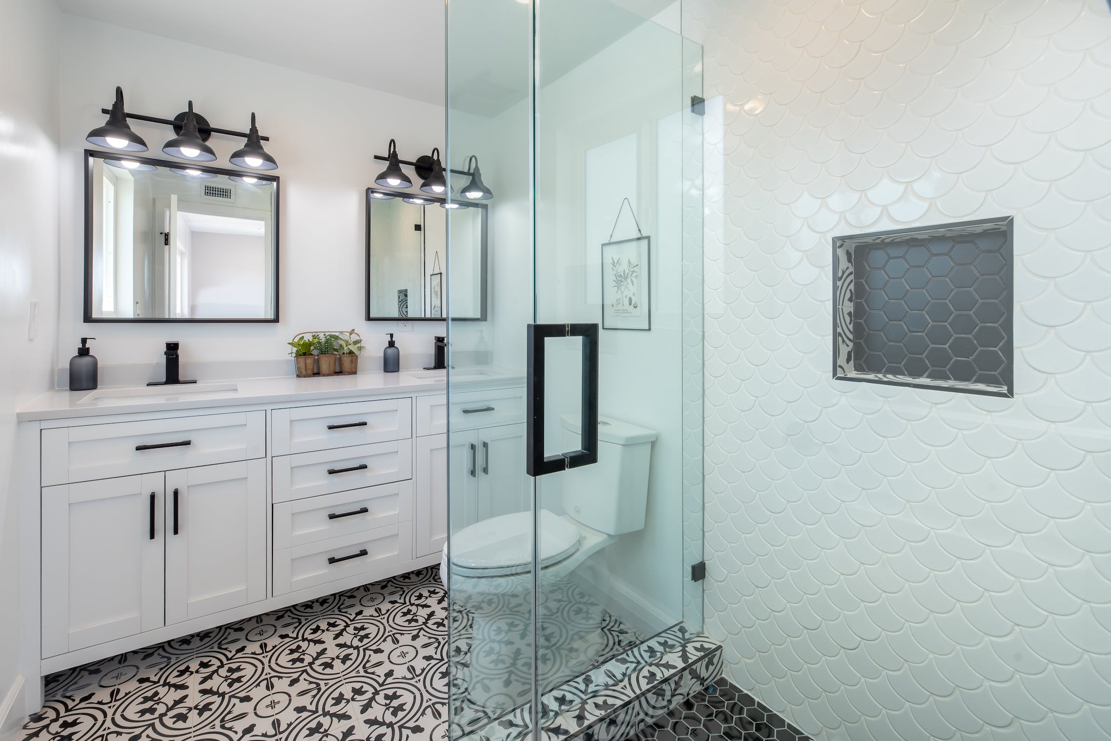 Modern remodeled bathroom with double vanity and tiled walk-in shower